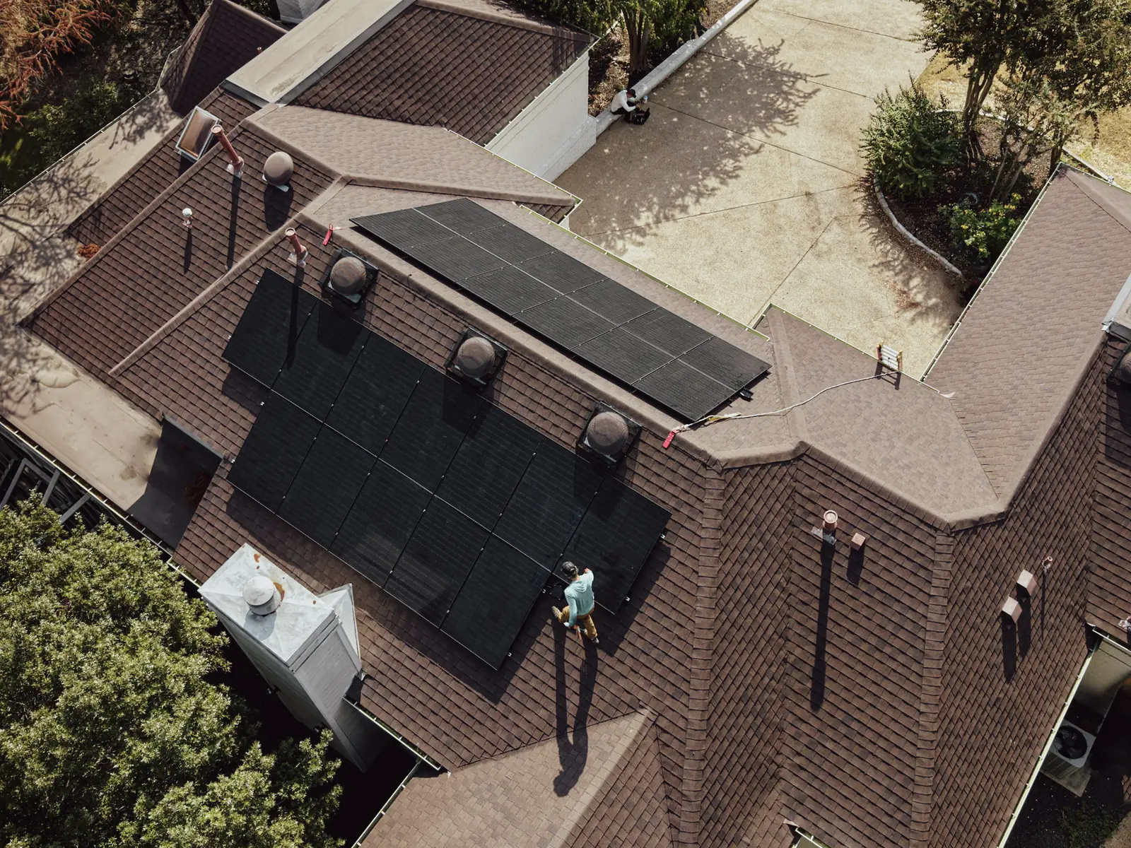 Overhead view of an Honest Solar installer setting the last modules of a rooftop solar array
